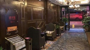 A lobby with a reception desk, seating area, and a chandelier. - Aegean Sea Theme Hotel (Nanping)