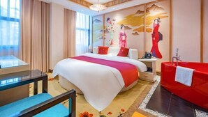 A hotel room with a bed, a red sofa, a desk, and a wall with a mural. - Aegean Sea Theme Hotel (Nanping)