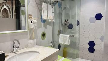 Un baño con lavabo, espejo, toallero y zona de ducha.