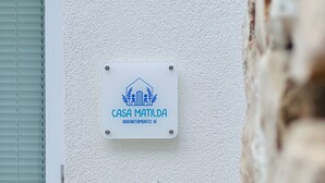 Une enseigne indiquant « CASA MATILDA APARTAMENTO 15 » sur un mur à texture.