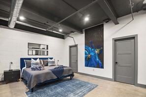 A bedroom with a bed, a large painting, a wardrobe, and a mirror on the wall. - Historic Newark Station- 10% off Earthworks Cafe (Newark)