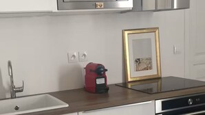 Eine Küche mit Mikrowelle, Kaffeemaschine, Spüle und einem gerahmten Bild auf der Arbeitsplatte.