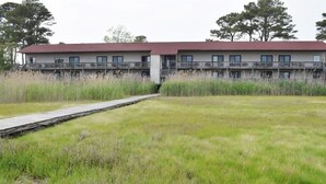 Un bâtiment doté d’un toit rouge, de plusieurs balcons et d’une terrasse en bois menant à l’entrée.