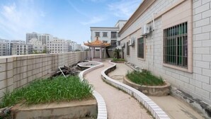 A rooftop garden with a curved pathway, a decorative gazebo, and a building with a tiled exterior. - Fu Quan Hotel (Wuchuan Haibin Bus Terminal) (Wuchuan)