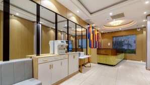 A modern hotel lobby with a reception desk, seating area, and a large window offering a view. - Fu Quan Hotel (Wuchuan Haibin Bus Terminal) (Wuchuan)