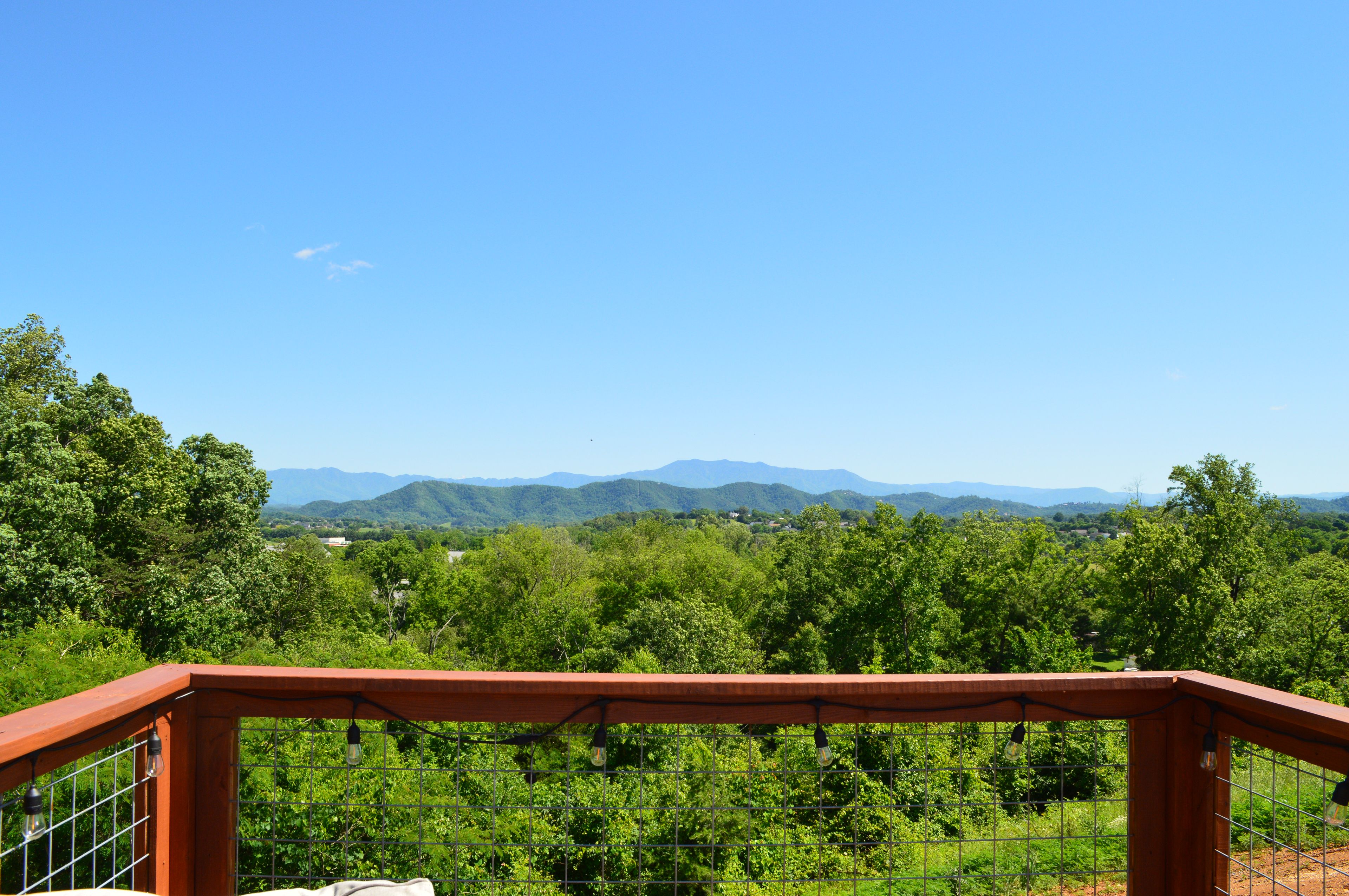 Un vignoble entouré d’une clôture en bois, offrant une vue dégagée sur les montagnes lointaines.