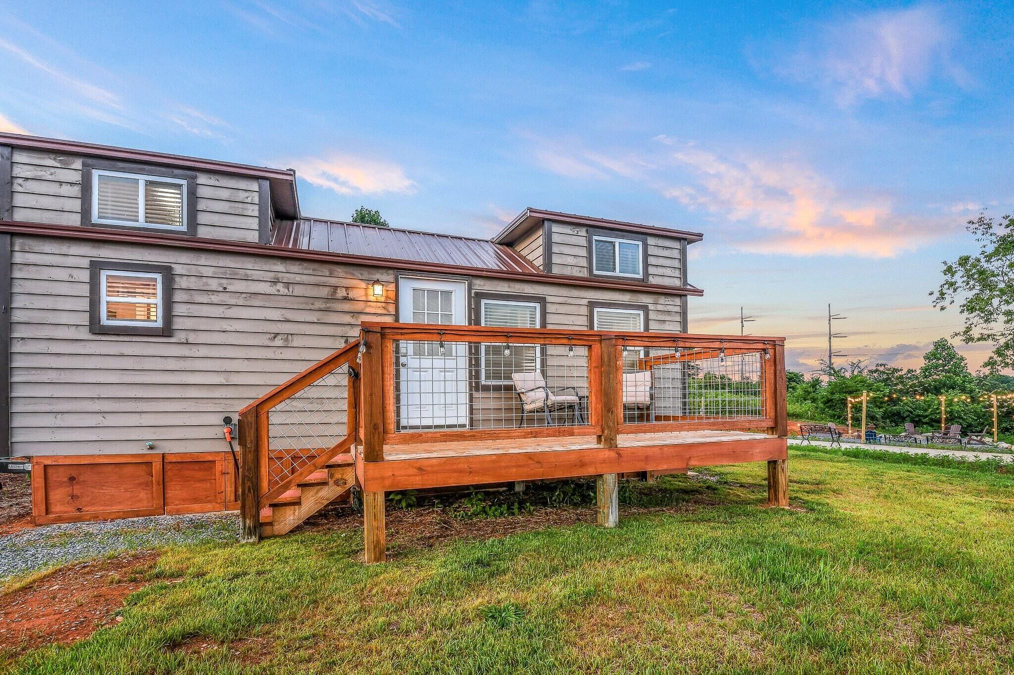 A two-story house with a wooden deck and a covered outdoor seating area.