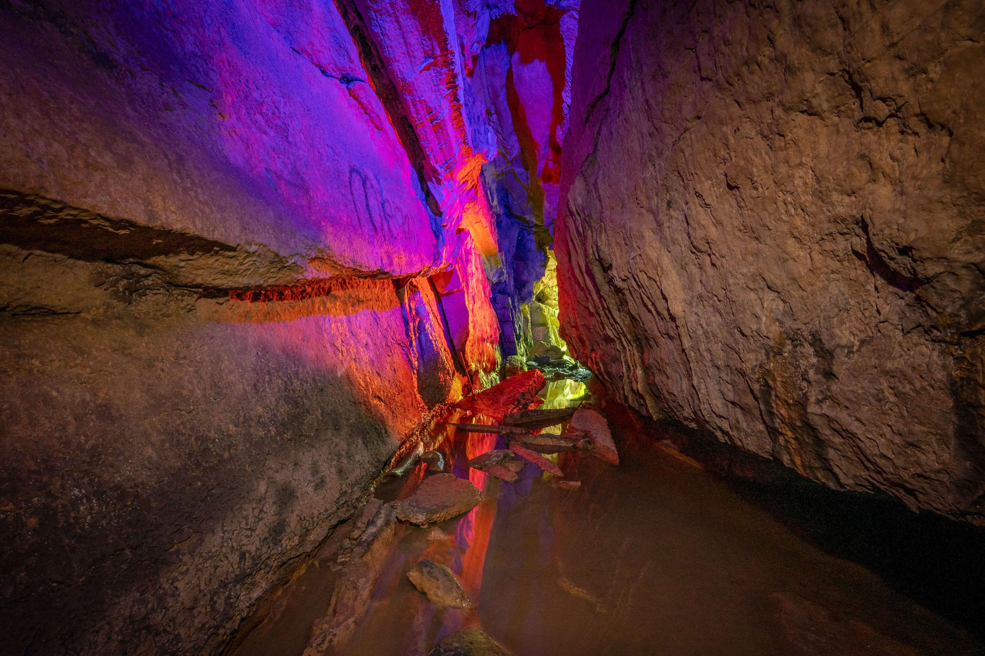 A narrow passageway with rocky walls and a reflective water surface.