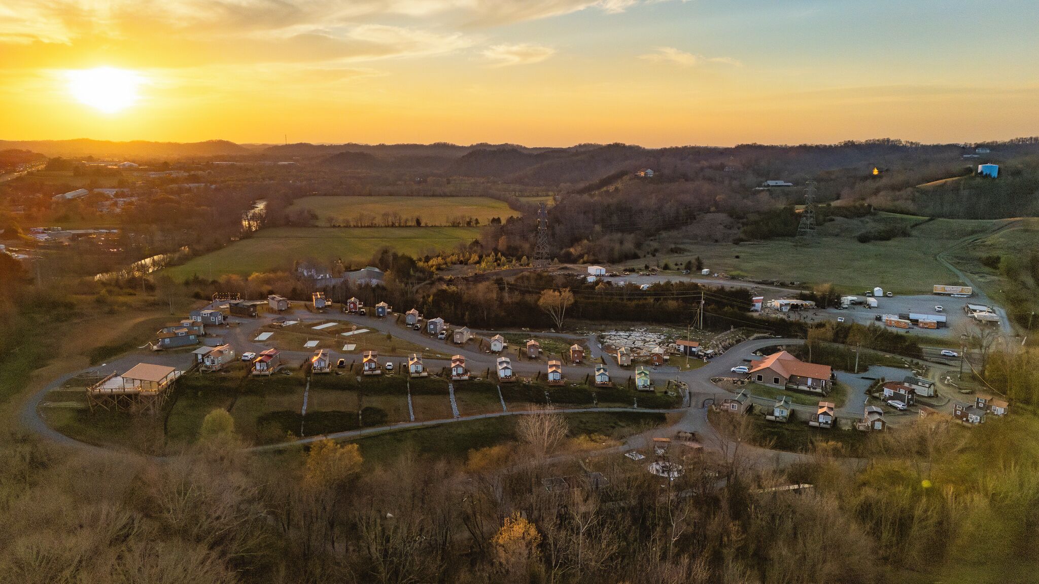 An aerial view of a rural area with a cluster of houses and a road.