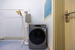 A laundry area with a washing machine and a drying rack. - Meiwu Hotel (Lanzhou Dngfanghong Square Railway Bureau Store) (Lanzhou)
