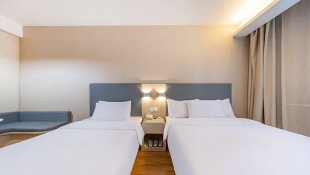 A hotel room with two beds, a bedside table, a lamp, and a blue chair. - Meiwu Hotel (Lanzhou Dngfanghong Square Railway Bureau Store) (Lanzhou)