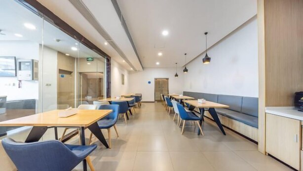 A modern dining area with tables and chairs, a bench, and a counter. - Meiwu Hotel (Lanzhou Dngfanghong Square Railway Bureau Store) (Lanzhou)