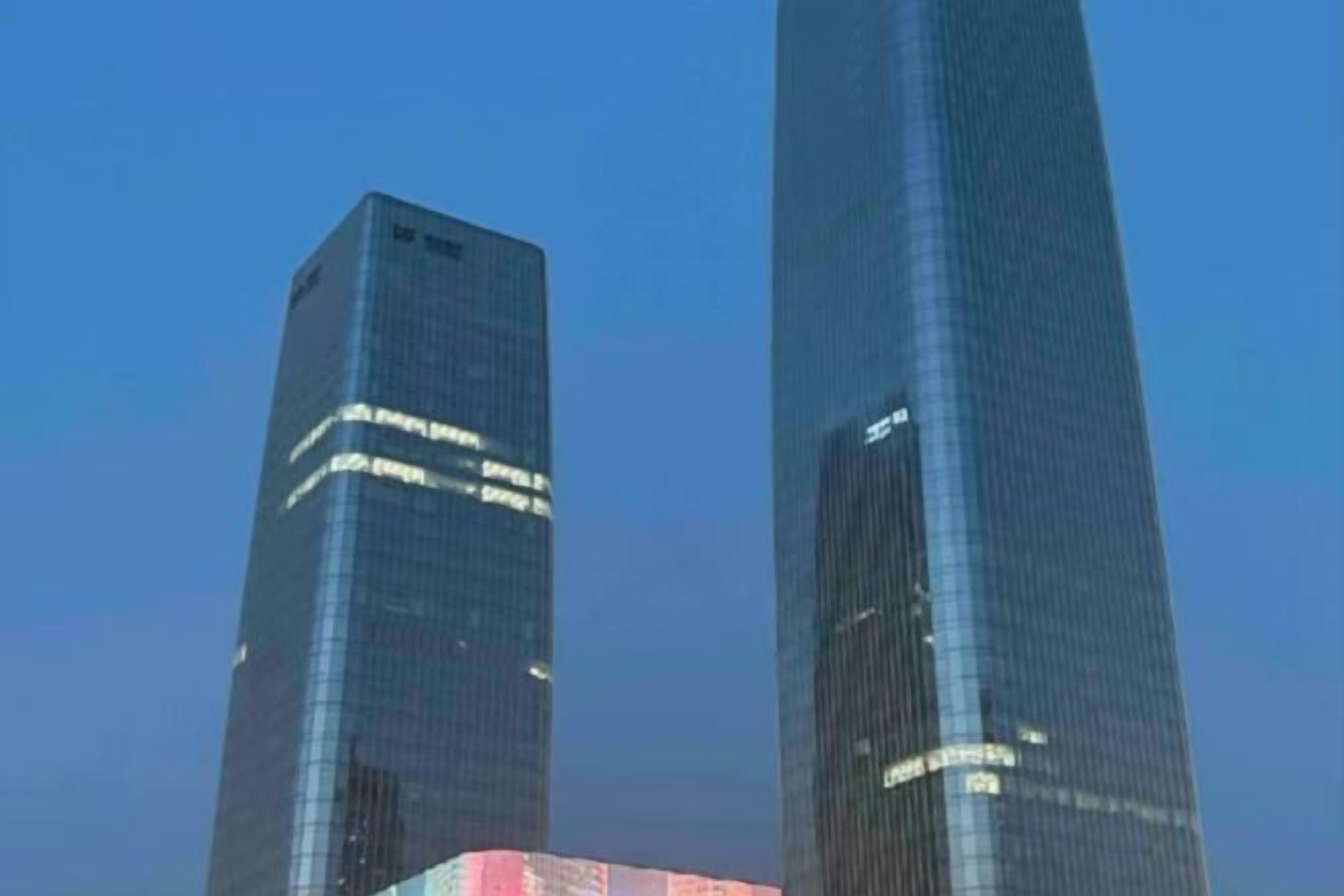 Deux gratte-ciel modernes et imposants, dotés de façades en verre réfléchissant.