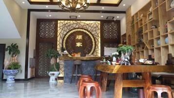 A lobby with a reception desk, seating area, and decorative plants.