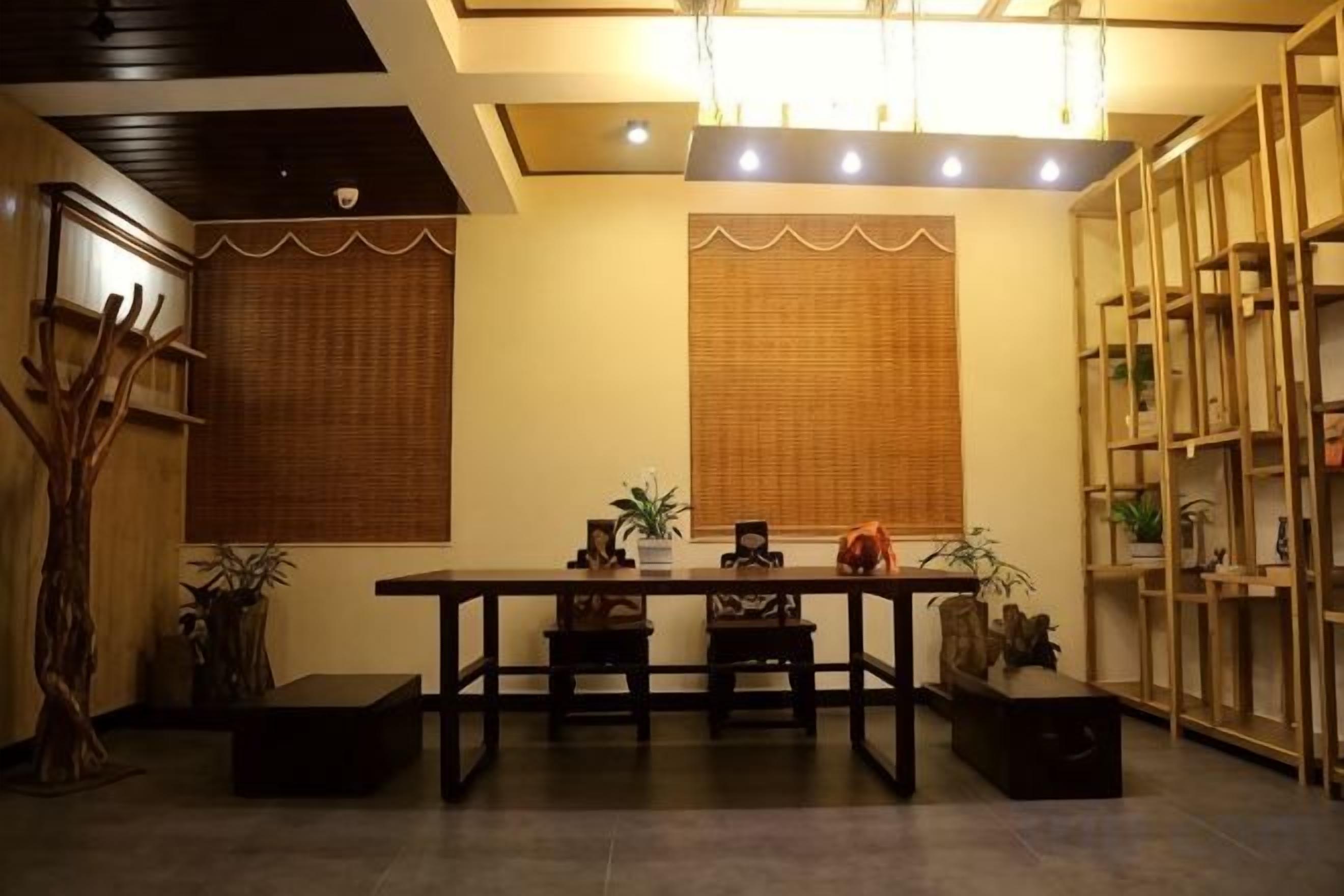 A dining area with a table and chairs, a wooden cabinet, and a shelving unit.