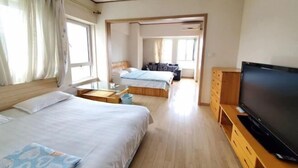 A hotel room with two beds, a TV, and a wooden TV stand. - Xingfu Apartment Hotel (Dalian)