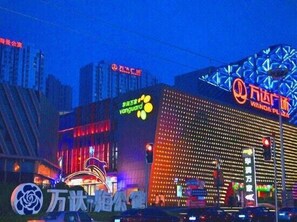 A building with a large, illuminated sign for Wanda Plaza. - Yisuli Hotel (Dalian Hi-tech Wanda Plaza) (Dalian)