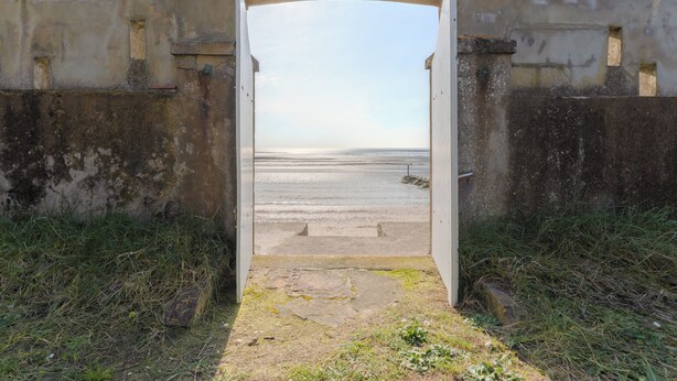 An open doorway leading to a beach with a concrete wall and a tiled roof. - L'Embrun - Accès direct plage - Jardin (La Bernerie-en-Retz)