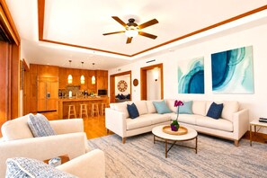 Ein modernes Wohnzimmer mit einer Couch, einem Couchtisch und einer Küche im Hintergrund.