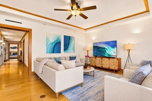 A modern living room with a sofa, armchairs, a coffee table, and artwork on the walls.