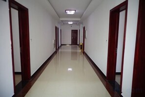A long, narrow hallway with doors on both sides, leading to a room at the end. - Longhushan Laiping Hostel (Guixi)