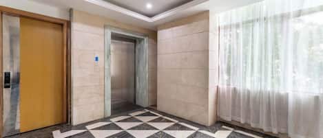 An elevator, a door, and a check-in counter in a hotel lobby.
