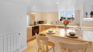 Una cocina moderna con armarios de madera, una isla central y vistas al exterior.