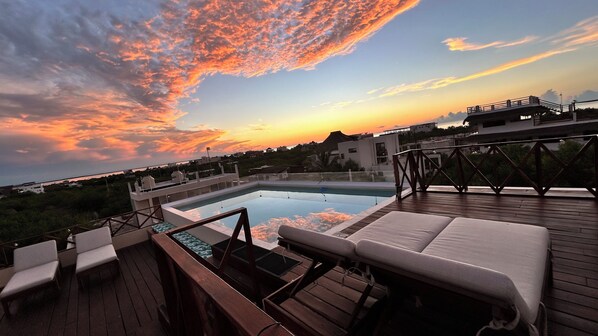 A rooftop pool area with lounge chairs and a view of the sunset. - sunsteps casa holbox  (Isla Holbox)