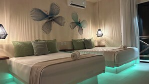A hotel room with two beds, a large window with curtains, decorative wall art, and a staircase visible through the window. - sunsteps casa holbox  (Isla Holbox)