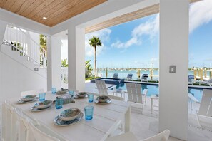 Ein Essbereich mit Blick auf einen Yachthafen und Pool.