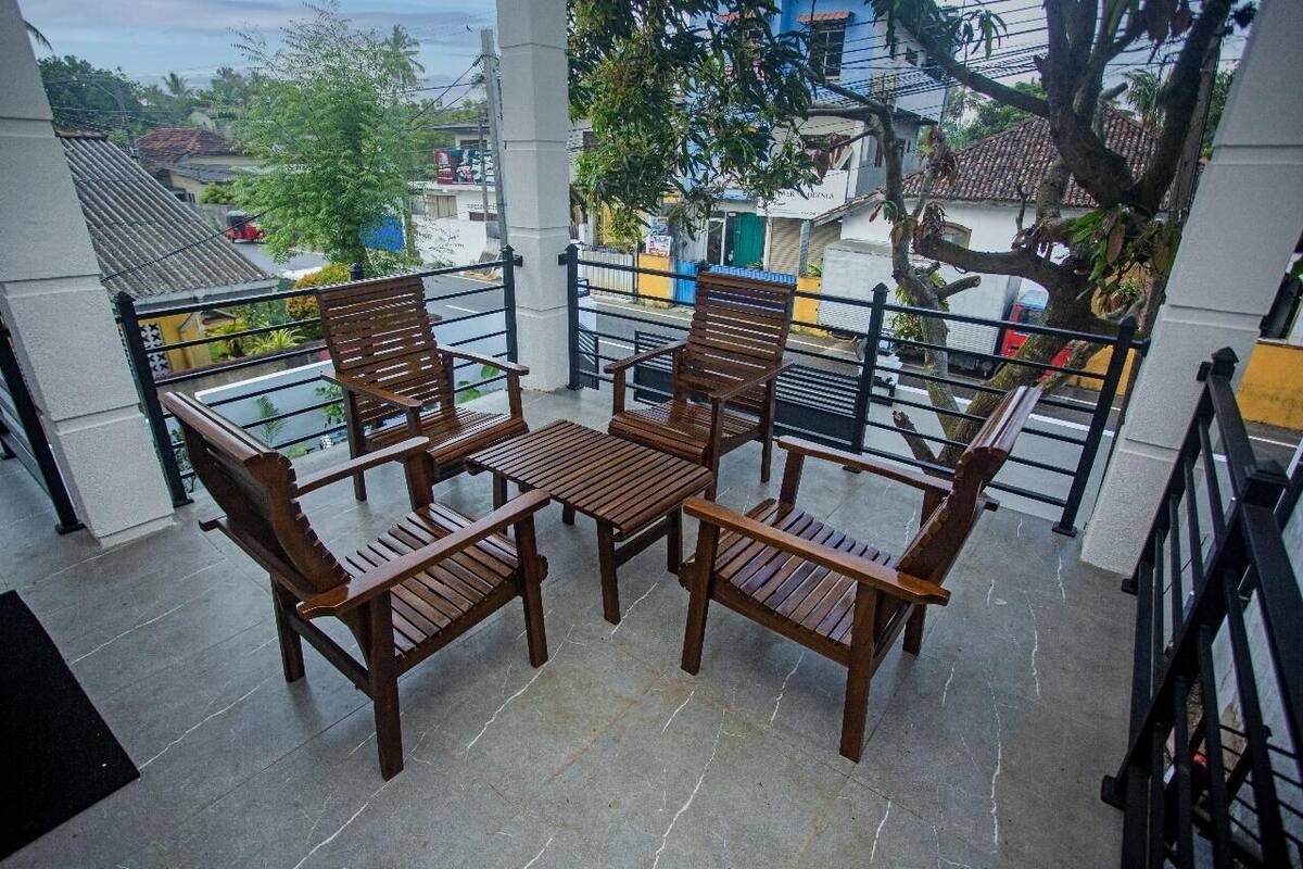 Un balcón con muebles de madera y vistas del barrio.