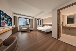 A hotel room with a bed, a desk, a chair, a small table, and a television. - Bolianhui Hotel (Chongqing Southwest Hospital) (Chongqing)