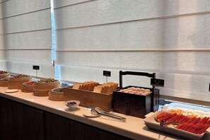 Un buffet proposant divers plats et un distributeur d’eau.