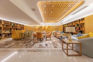 A modern interior with a central seating area, bookshelves, and a decorative ceiling. - Bolianhui Hotel (Chongqing Southwest Hospital) (Chongqing)