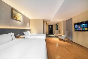 Ein modernes Hotelzimmer mit zwei Betten, einem Fernseher und einem Bild an der Wand.