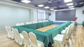 A conference room with a long table, white chairs, and a green tablecloth. - Bolianhui Hotel (Chongqing Southwest Hospital) (Chongqing)