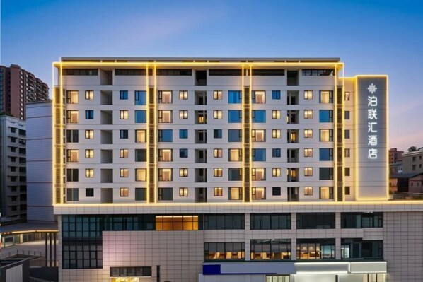 A multi-story hotel with a modern facade, illuminated windows, and a prominent signage indicating the hotel's name. - Bolianhui Hotel (Chongqing Southwest Hospital) (Chongqing)