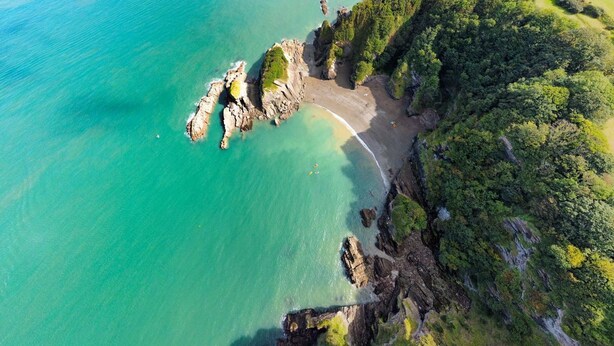 An aerial view of a coastal area with a beach, rocky outcrops, and dense greenery. - Sleeps 12, swimming pool, sea views, games rooms (Watermouth)