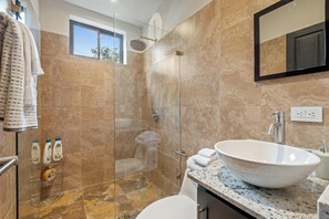 A modern bathroom with a glass-enclosed shower, a large white sink, and a marble-tiled floor. - Relaxing 2 BR  Beach & Pool  Condo Unit2 (Brasilito)