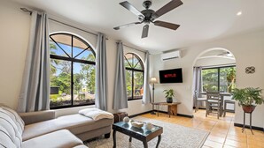 A living room with a sofa, a coffee table, and a TV. - Relaxing 2 BR  Beach & Pool  Condo Unit2 (Brasilito)
