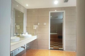 Un baño con dos lavamanos, un espejo y una zona de ducha.