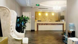 A hotel reception area with a marble reception desk, a chandelier, and a water dispenser. - Margarita Boutique Hotel (Guangde)