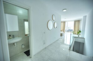Un baño moderno con lavabo, espejo e inodoro.