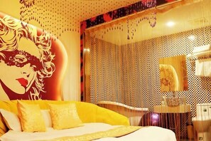 Una camera d'albergo con un letto grande, un bagno con vasca e uno specchio che riflette l'ambiente.