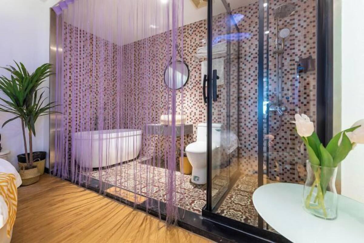 A modern bathroom with a glass shower enclosure, a bathtub, and a toilet.