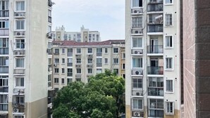 Un immeuble résidentiel de grande hauteur, doté de nombreux balcons et de climatiseurs.