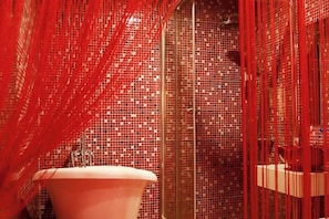 Ein Badezimmer mit einem rosa Waschbecken, gefliesten Wänden und roten Vorhängen.