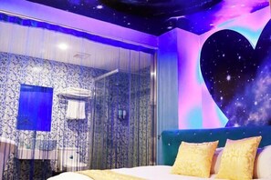 Una camera da letto con un letto, una grande decorazione a forma di cuore sulla parete e un angolo doccia.