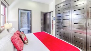 A hotel room with a large bed, a wardrobe, and a door leading to a balcony. - Ocean view 2nd floor, luxury 1 bedroom condo at EL FARO by DPM (Playa del Carmen)