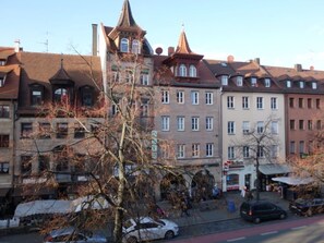 Une rangée de bâtiments européens traditionnels, chacun présentant un style architectural distinct, notamment une tour imposante et une variété de modèles de fenêtres.
